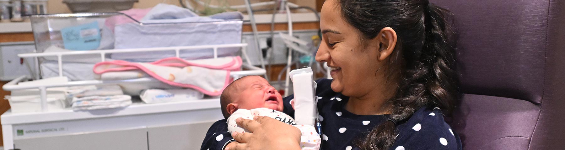 New mother holding her infant baby while seated