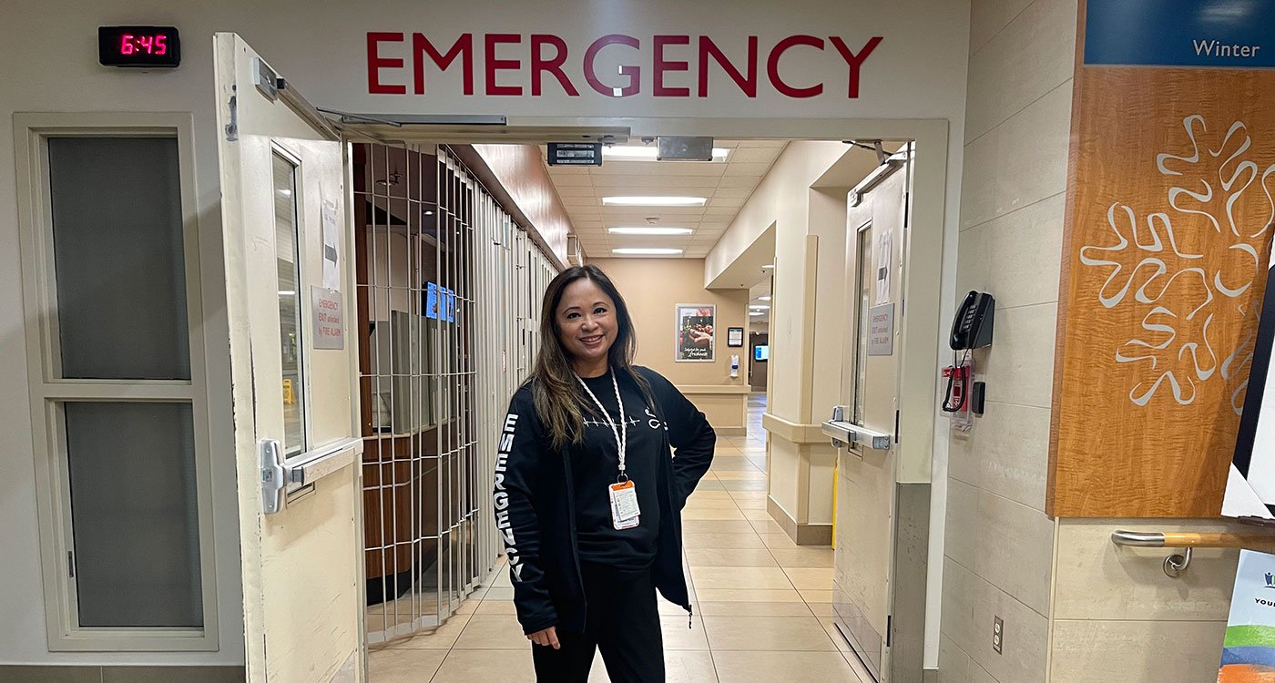 Lyda Gabrang-Jorge, Emergency Registered Nurse, stands in front of the interior Emergency entrance at Brampton Civic Hospital